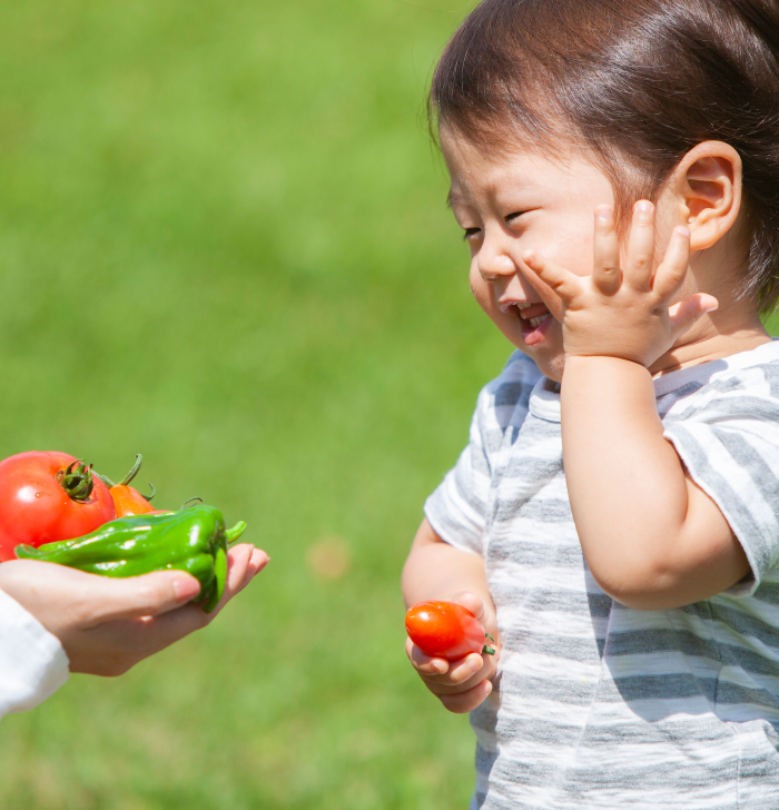 ”野菜を受けとる笑顔の子ども”